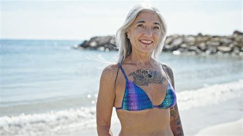 Middle Age Grey Haired Woman Tourist Smiling Confident Wearing Bikini At Beach Stock Image