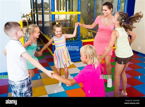 Children Dancing With Teacher To Music In Class At School Stock Photo