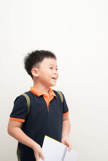 Niño feliz con libro aislado sobre fondo blanco Foto Premium