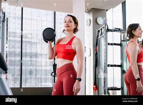 Mature Woman Lifting Dumbbell At Gym Stock Photo Alamy