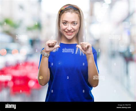 Junge blonde Frau über isolierte Hintergrund überzeugt mit einem Lächeln auf dem Gesicht zeigen