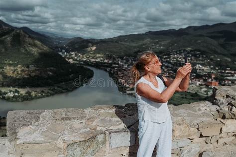 Mature Woman Tourist Takes Pictures On Observation Deck Confluence Of Two Rivers Aragvi And Kura