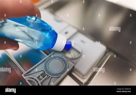 man pours rinse aid   dishwasher compartment stock photo alamy