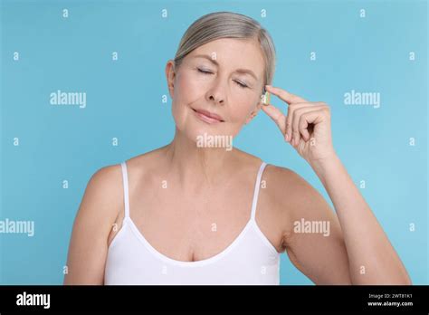 Beautiful Woman With Vitamin Capsule On Light Blue Background Stock