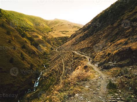 Woman hike down in KAzbegi national park gergeti glacier trail pathway