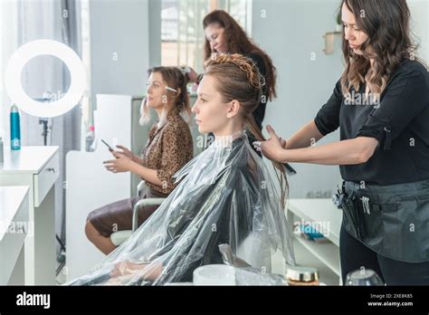 Hairdresser Brushing Long Blonde Hair With Brush In Beauty Salon Stock Photo Alamy