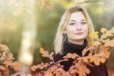 La Fille Blonde Pose Derrière Les Branches D un Chêne Photo stock Image of cheveu visage