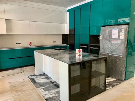 Изумрудная кухня с мраморной столешницей и белыми шкафами