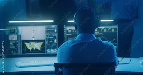 African American Flight Control Employee Sits In Front Of Computers