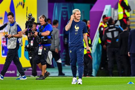 The Soccer Player Is Walking On The Field With His Hand Up To His Ear