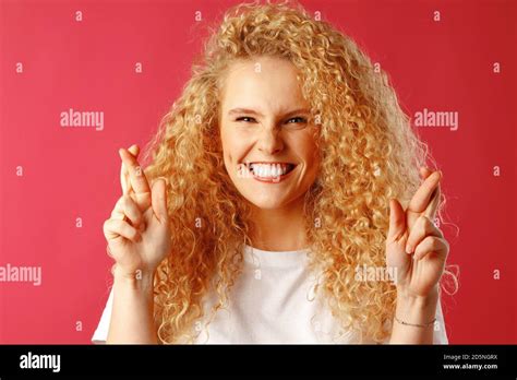 Excited Young Woman Holding Crossed Fingers For Luck Stock Photo Alamy