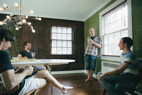 Group Of Gay Friends Having Drinks And Chatting In A Dining Room On A Weekend Afternoon By