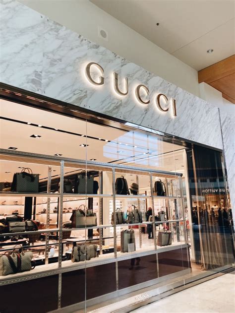 A Gucci Store Front With Marble Walls And Glass Display Cases Filled