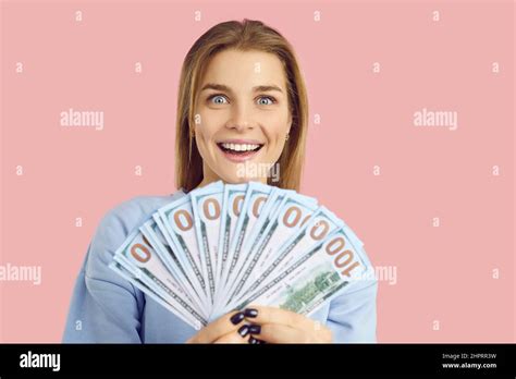 Happy Surprised Young Woman Who Has Won A Lot Of Cash Holding A Fan Of