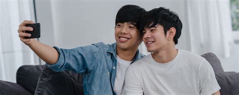 Romántica pareja gay joven selfie divertido por teléfono celular en casa asiático amante