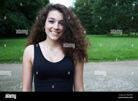 Schöne junge Frau mit brunette langes lockiges Haar in der Natur