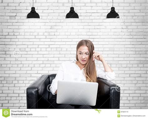 Femme Blonde Dans Le Fauteuil Ordinateur Portable Brique Photo Stock Image Du Moquerie Beau