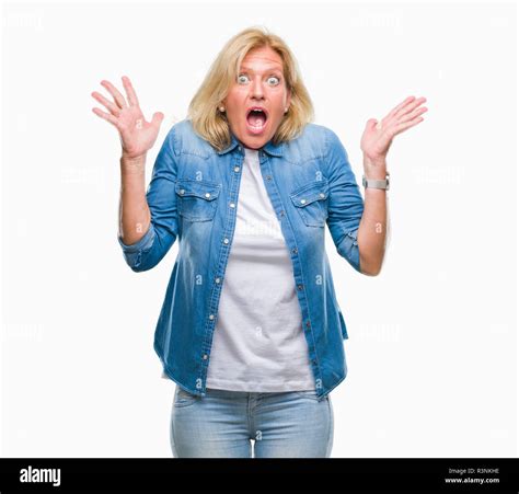 Blonde Frau mittleren Alters über isolierte Hintergrund verrückt und erstaunt Feiern für den