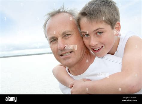 Portrait Of Man Carrying Young Boy On His Back Stock Photo Alamy