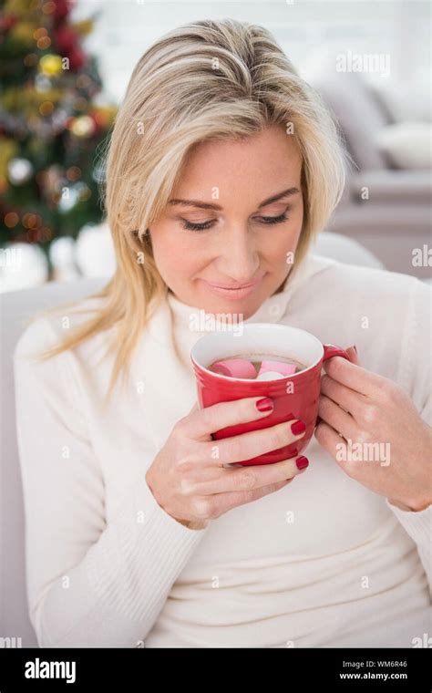 Blonde Having Hot Chocolate On The Couch At Christmas At Home In The Living Room Stock Photo Alamy