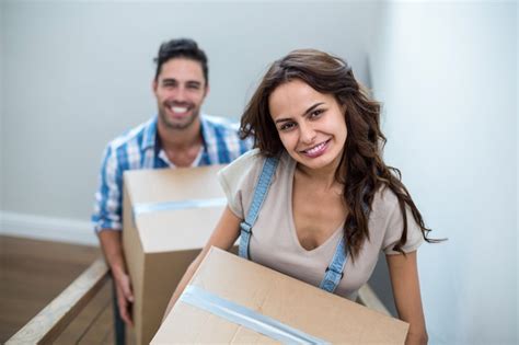 Premium Photo Portrait Of Smiling Couple Holding Cardboard Boxes