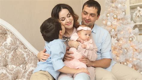 Same Sex Couple Sleeping On Their Sofa With Their Baby Son Sleeping On One Of Their Chests