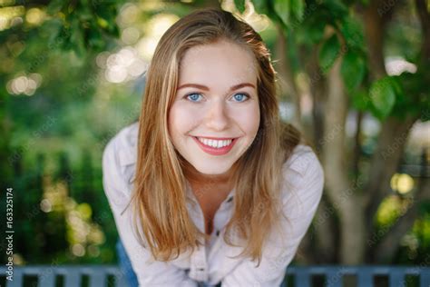 Closeup Portrait Of Beautiful Smiling White Caucasian Girl Woman With Long Blonde Hair And Blue