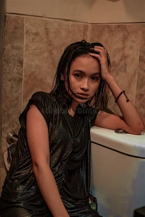 Hot And Wet Asian Girl Poses With Sensual Style While Wearing Black Wet Dresses Stock Image