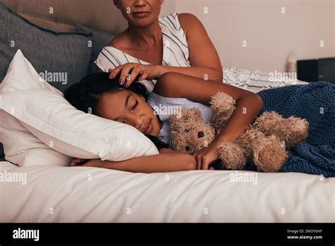 Mature Woman Adjusting The Hair Of Her Granddaughter While She Sleeping Stock Photo Alamy