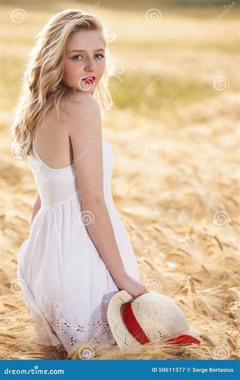 Belle Jeune Fille Blonde Seule Dans La Robe Blanche Avec Le Chapeau De Paille Image Stock