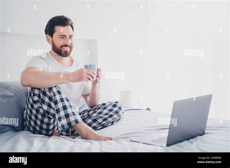 Photo Of Funky Happy Mature Guy Sleepwear Pajama Sitting Bed Enjoying Bebverage Texting Modern