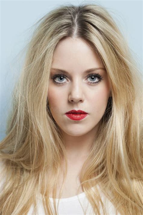 Portret Van De Jonge Blonde Sigaret Van De Vrouwenholding Tegen Lichtblauwe Achtergrond Stock