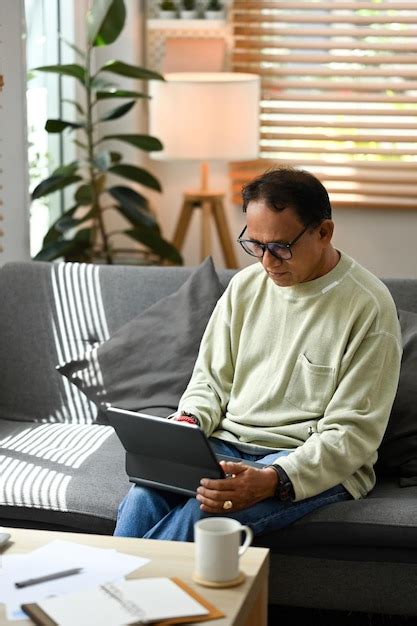 Premium Photo Happy Mature Man Sitting On Couch And Checking Email
