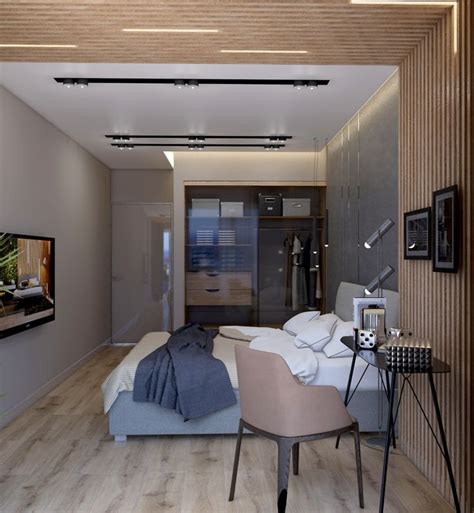 a bedroom with a bed, chair and television on the wall next to each other