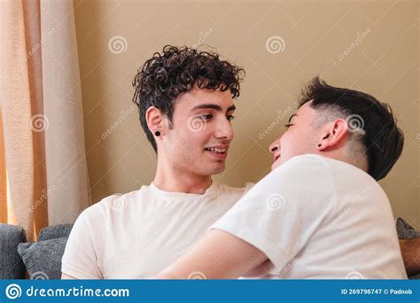 Snuggling Latin Gay Couple In Pajama On The Sofa Talking And Laughing Diversity Of Romantic