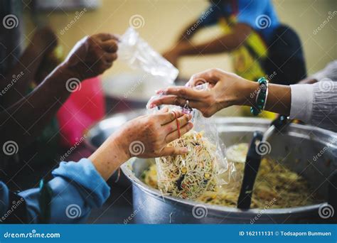 The Hands Of The Poor Receive Charity Food Service From Volunteers