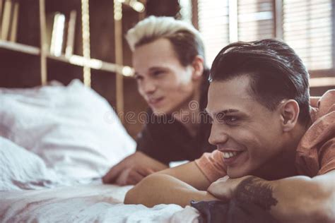 Pares Gay Alegres Que Descansan Junto En Casa Foto De Archivo Imagen De Feliz Atractivo