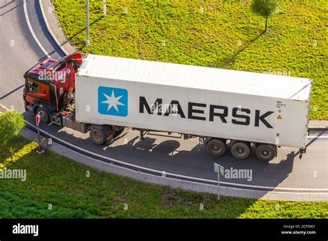 Truck with trailer and green container company Maersk on city highway ...