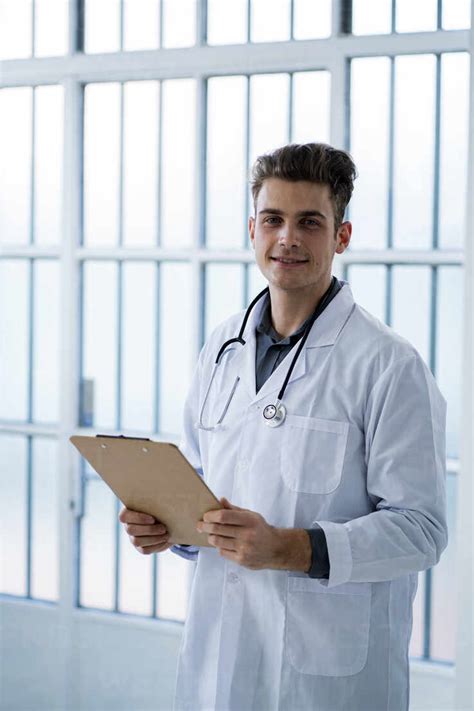 Male Doctor Holding Clipboard In Hospital Stock Photo