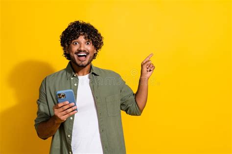 Photo Of Young Funny Wavy Haired Mexican Guy Using His Smartphone