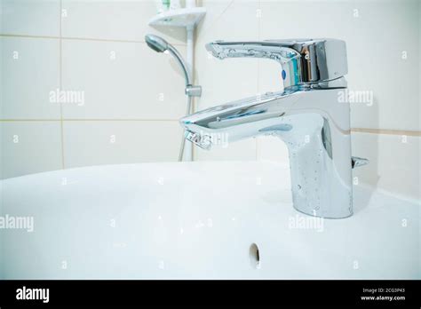 Chromed Metal Faucet For Hot And Cold Water In A Modern Bathroom Stock Photo Alamy