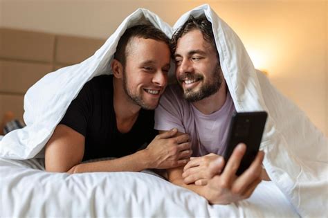 Feliz pareja gay teniendo momentos tiernos en el dormitorio relación de amor homosexual y