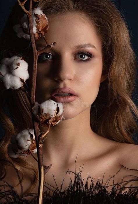 Studio Portrait Of Beautiful Blonde Model With Perfect Skin And Makeup Posing In The Shadows