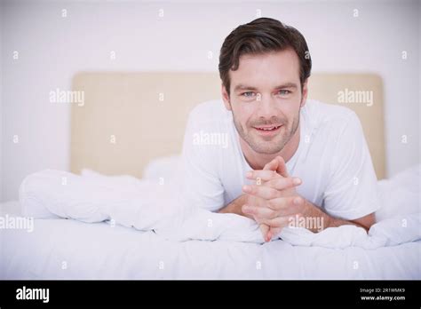 Relaxing In Bed Portrait Of A Handsome Young Man Lying On His Stomach