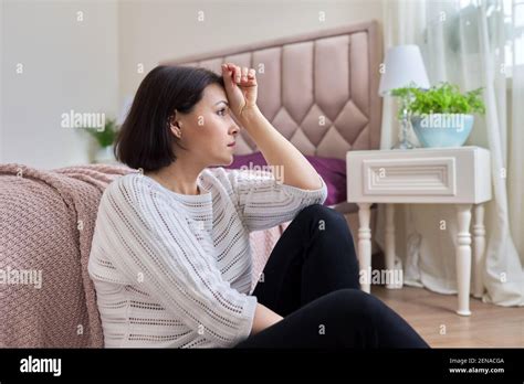 Unhappy Tired Depressed Mature Woman Sitting At Home On The Floor Stock