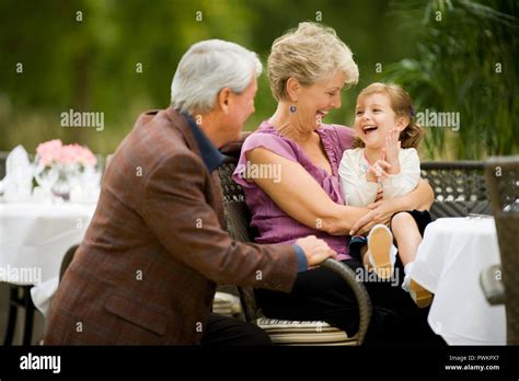 Jeune fille assise avec son grand père et grand mère mature à l extérieur Photo Stock Alamy