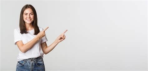 Free Photo Attractive Smiling Brunette Girl Pointing Fingers Upper Right Corner Showing Logo