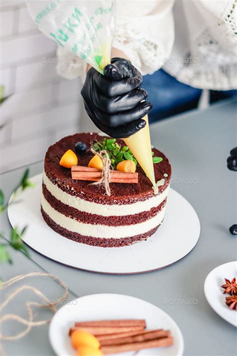 A Pastry Chef Decorates A Chocolate Naked Cake With Drips Of White