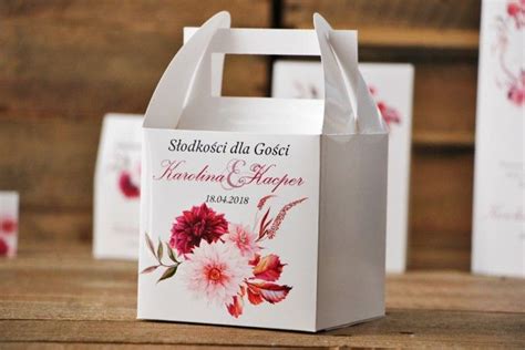 Small White Bags With Flowers On Them Sitting On A Table