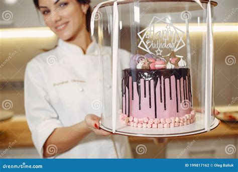 Pasteleiro De Uniforme Decora O Bolo Foto De Stock Imagem De Bolinho